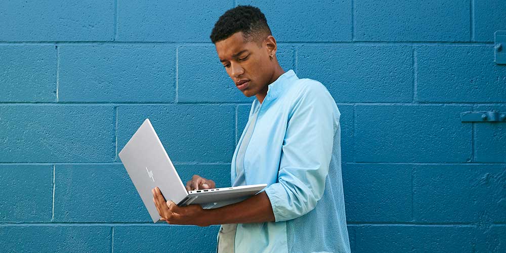 A man works outdoor using a HP ENVY 15 Laptop